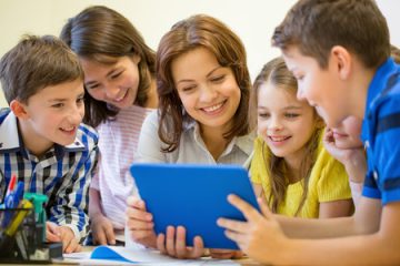 35173893 - education, elementary school, learning, technology and people concept - group of school kids with teacher looking to tablet pc computer in classroom